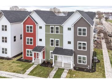 View of newly-constructed townhomes, featuring colorful exteriors, well-kept lawns, and inviting front porches at 2420 Winthrop Ave, Indianapolis, IN 46205