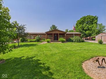 Inviting log home featuring a sprawling lawn, charming front porch, and lush landscaping at 2895 E 600 S, Markleville, IN 46056