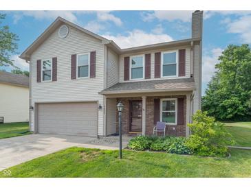 Charming two-story home with brick front porch and well-manicured lawn in a desirable neighborhood at 6635 Blackthorn Dr, Indianapolis, IN 46221