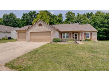 Charming brick home featuring a three-car garage and a well-manicured front lawn at 7372 Oakview Dr, Avon, IN 46123