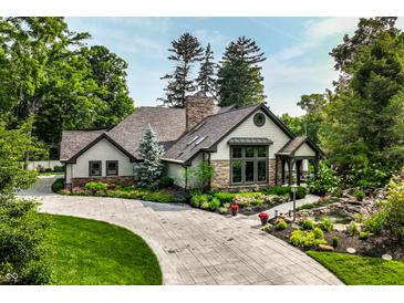 Charming home featuring stone and shingle exterior, lush landscaping, stamped driveway and inviting entrance at 8651 Emerald Ln, Indianapolis, IN 46260
