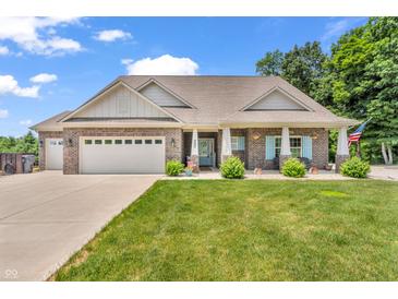 Charming brick home with a well-manicured lawn, attached garage, and a quaint covered porch at 9231 E Poynter Dr, Morgantown, IN 46160