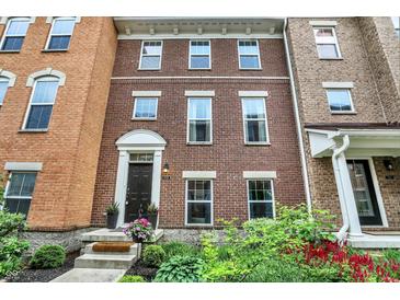 Charming brick townhome featuring a welcoming entrance and well-maintained landscaping at 9508 Oakley Dr, Indianapolis, IN 46260