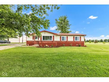 Charming ranch-style home with a well-manicured lawn, colorful landscaping, and a red accent roofline at 10965 W Base Line Rd, Jamestown, IN 46147