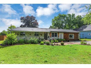 Charming single-story home featuring combination brick and wood facade and lush landscaping at 12606 Markay Dr, Fishers, IN 46038