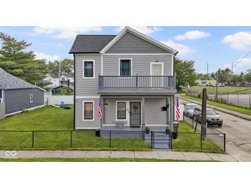 Charming two-story home with a balcony, well-maintained lawn, and a classic gray exterior at 134 N Elder Ave, Indianapolis, IN 46222