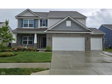 Charming two-story home with a two-car garage, brick accents, and a well-manicured lawn at 1439 Silver Pine Ln, Sheridan, IN 46069