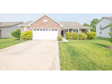 Charming brick home featuring a two-car garage, well-maintained lawn, and inviting front porch at 2402 Foxtail Dr, Plainfield, IN 46168
