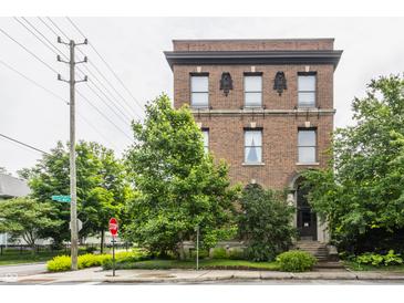 Brick building featuring symmetrical windows, decorative stone accents and mature trees at 3959 Central Ave, Indianapolis, IN 46205