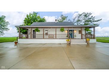 Charming home featuring a covered porch with wood beams and a welcoming blue front door at 4491 W 600 N, Anderson, IN 46011