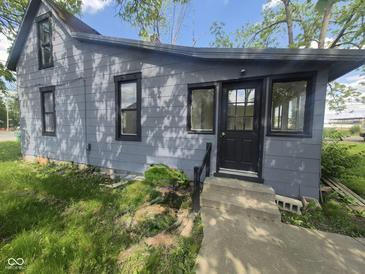 Home exterior featuring gray siding, black trim, and a concrete front porch and steps at 711 W Centennial Ave, Muncie, IN 47303