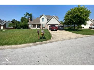 Charming two-story home with a well-manicured lawn, mature tree and convenient driveway parking at 902 St Andrews Dr, Avon, IN 46123