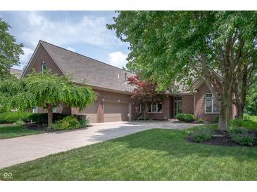 Beautiful brick home featuring a three-car garage, manicured lawn, and mature trees at 3545 Inverness Blvd, Carmel, IN 46032