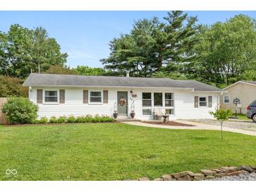 Charming single-story home with a well-manicured lawn and inviting curb appeal with beautiful trees in the background at 544 Everling Dr, Morgantown, IN 46160