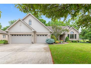 Charming brick home with a well-manicured lawn, mature trees, and a spacious three-car garage at 6980 White Oak Dr, Avon, IN 46123