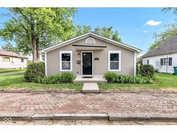 Charming single-story home featuring neutral siding and a quaint entrance with a brick path and manicured landscaping at 917 W Pearl St, Lebanon, IN 46052