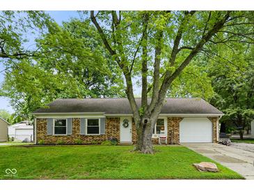 A well-maintained brick home with mature trees, a front lawn, and attached one car garage at 99 Old Trail Dr, Bargersville, IN 46106