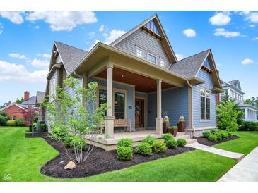 Charming blue two-story home with landscaped yard and inviting front porch at 12839 Bird Cage, Carmel, IN 46032