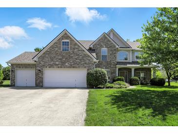 Charming two-story brick home with a three-car garage and manicured front lawn at 13355 Freenza Ct, Carmel, IN 46074