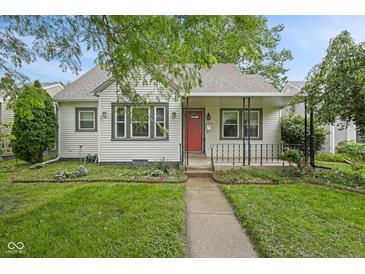Charming home featuring a well-manicured lawn, inviting walkway, and a cozy front porch with red door at 1739 Caldwell Pl, Columbus, IN 47201