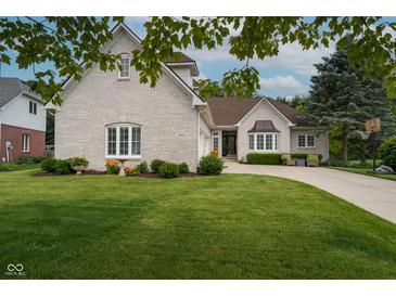 Charming brick home featuring a well-manicured lawn, curved driveway, and lush landscaping at 18432 Oriental Oak Ct, Noblesville, IN 46062