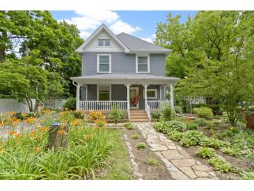 Charming two-story home featuring a welcoming front porch and professionally landscaped front yard with stone pathway at 23 S Downey Ave, Indianapolis, IN 46219