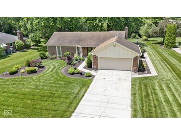 Lovely single-story home with a brick facade, attached garage, and well-manicured front yard at 272 N Peterman Rd, Greenwood, IN 46142