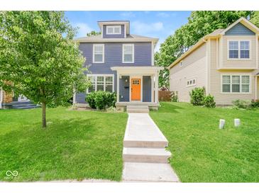 Charming blue two-story home featuring a bright orange front door, well-manicured lawn, and welcoming walkway at 3626 N Capitol Ave, Indianapolis, IN 46208