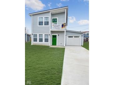 Charming two-story home with light gray siding, green door, and an attached garage on a lush lawn at 3813 N Lawndale Ave, Indianapolis, IN 46254