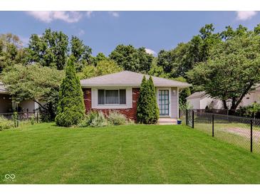 Charming single-story home with a well-manicured lawn, mature trees, and brick accents at 4218 E 18Th St, Indianapolis, IN 46218