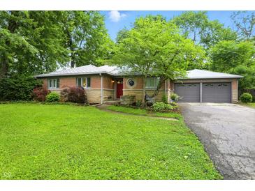 Charming single story home with brick and stone exterior, mature trees, and a well-manicured lawn at 4340 Ashbourne Ln, Indianapolis, IN 46226