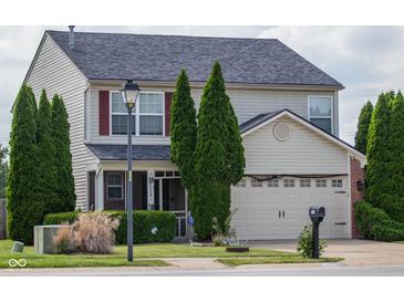 Charming two-story home with well-maintained landscaping, a two-car garage and traditional curb appeal at 6524 Amick Way, Indianapolis, IN 46268