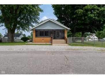 Charming home with a screened-in porch and well-maintained front yard at 7727 Huff St, Indianapolis, IN 46259
