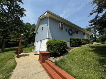 Charming two-story home with light blue siding, green lawn, and inviting walkway at 8664 S Nash Dr, Nineveh, IN 46164