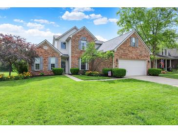 Beautiful brick home with manicured lawn, blue sky, and trimmed hedges at 9653 Cypress Way, Carmel, IN 46032
