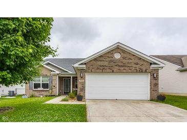 Charming brick home featuring a two-car garage and a well-maintained lawn with beautiful landscaping at 3872 Dusty Sands Rd, Whitestown, IN 46075