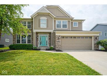 Charming two-story home featuring a manicured lawn, a two-car garage, and a welcoming turquoise-colored front door at 6471 W Clearview Dr, McCordsville, IN 46055