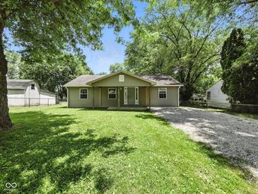 Charming single-story home with a well-maintained lawn, mature trees, and a gravel driveway at 7434 N Green Meadows, Fairland, IN 46126