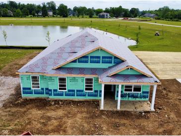 An exterior view of a home under construction with a pond in the background in a lovely community at 7877 Magnolia St, New Palestine, IN 46163