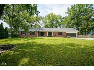Well-maintained brick home with lush green lawn and mature trees offering great curb appeal at 1015 Fox Hill Dr, Indianapolis, IN 46228