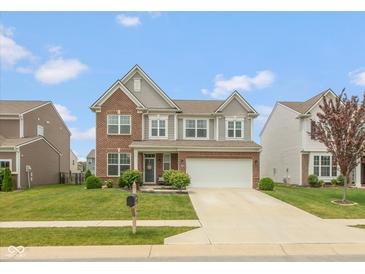Charming two-story home featuring brick and vinyl siding, a well-manicured lawn, and an attached two-car garage at 10334 Deercrest Ln, Indianapolis, IN 46239