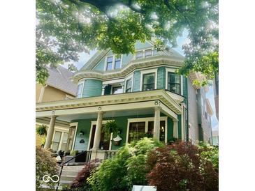 Beautiful two-story home featuring a welcoming porch and lush landscaping at 2050 N Alabama St, Indianapolis, IN 46202
