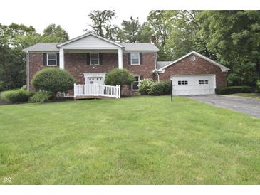 Charming two-story brick home featuring a landscaped front yard and attached garage at 44 Horseshoe Ln, Carmel, IN 46033