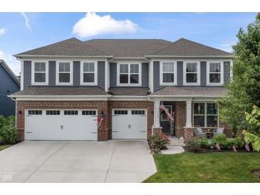 Charming two-story home with a brick and gray facade, three-car garage, and well-manicured lawn at 5917 Bartley Dr, Noblesville, IN 46062