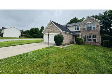 Two-story home featuring a brick facade, attached garage, and a well-manicured front lawn at 5938 Tybalt Ln, Indianapolis, IN 46254