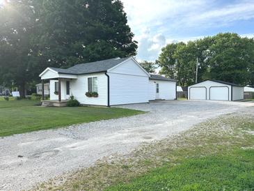 Exterior view of the house showing the gravel driveway, backyard and detached garage at 712 W Main St, Thorntown, IN 46071
