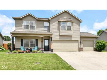 Charming two-story home with a well-manicured lawn, inviting front porch, and a convenient two-car garage at 2020 Treving Dr, Cicero, IN 46034