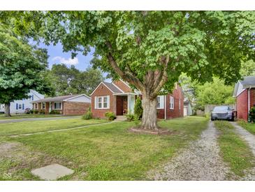 Charming brick home with a well-manicured lawn and a large tree providing ample shade at 241 Wehmeier St, Columbus, IN 47201