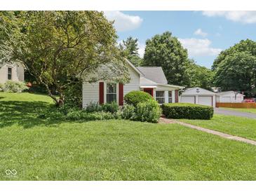 Charming single-story home with mature landscaping, red shutters, and a detached two-car garage at 409 N Sycamore St, Martinsville, IN 46151