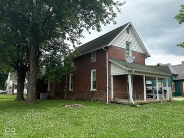 Charming brick home with a covered front porch and a spacious yard, offering classic appeal at 590 W Washington St, Martinsville, IN 46151